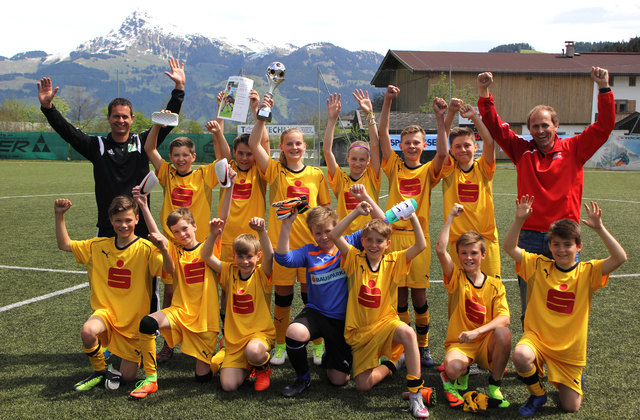 Hurra! Die Kicker der NMS Kitzbühel mit Betreuer Bernhard Prokopetz und SL-Bezirkskoordinator Walter Zimmermann jubeln über den insgesamt zweiten Titelgewinn in der Schulgeschichte.