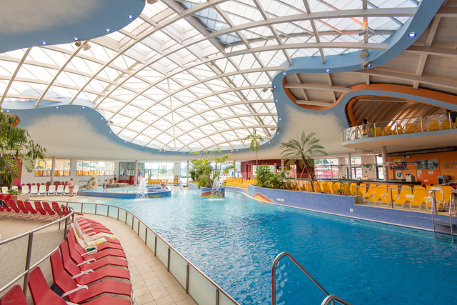 Der zentrale Thermenbereich mit Wellenbecken und Poolbar rechts im Hintergrund. | Foto: H2O Hoteltherme