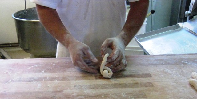 mit seinen flinken Händen formt der junge Bäcker Mohnweckerl