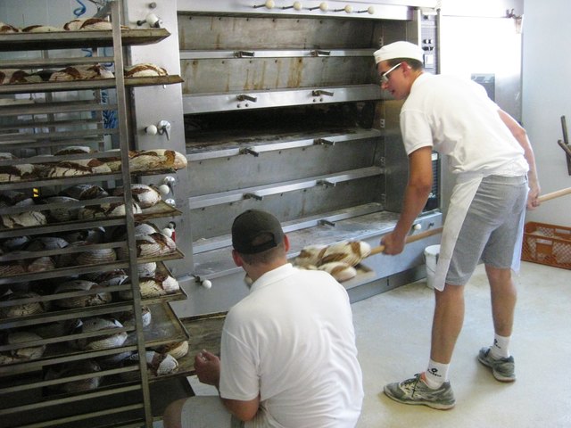 .. und die frischen, knusprigen Brotlaibe werden aus dem Backofen geholt
