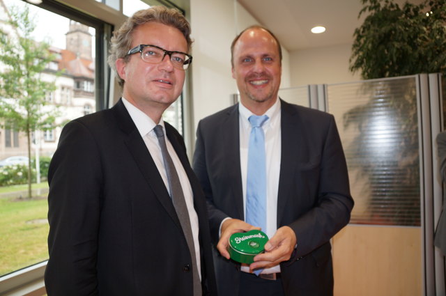 LR Christopher Drexler überreicht Bürgermeister Christian Vogel ein Geschenk.