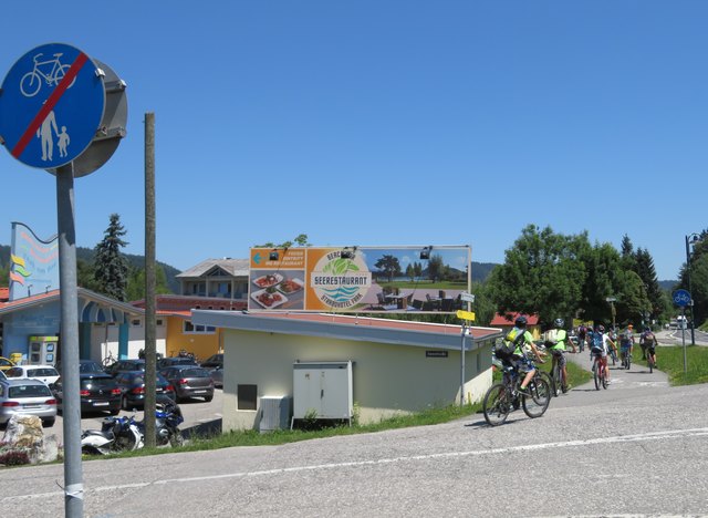 Wenn man mit dem Fahrrad vom Bauernmarktplatz kommt, gibt es hier schon die erste Unterbrechung. Um nicht über die Sperrlinie zu fahren, sollte man hier das Fahrrad über die Seestraße schieben. Beim Strandbad Faak am See beginnt das Chaos des "Faakersee-Radweges" (R1C)!