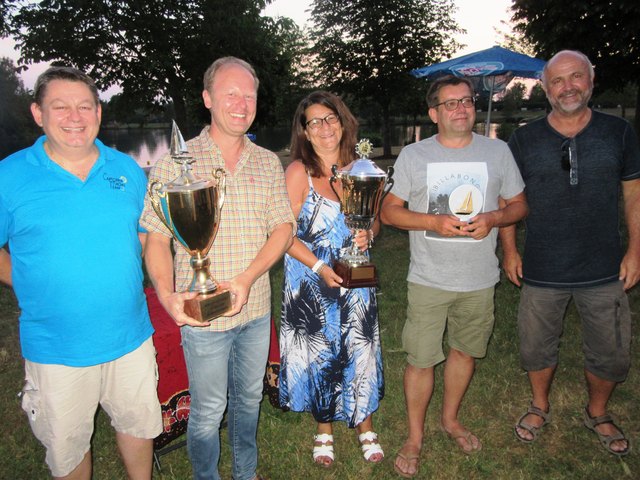 Beim Siegerbild fehlt nur Skipper Victor Vasiloiu: Maria Grasl mit dem Pokal für das Weiße Band, Richard Ortner hält den für's Blaue Band und Wolfgang Grasl das leichtere Siegandenken. Commodore Klaus Schäfer und Vize Felix Forster freuen sich mit.