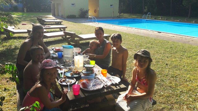 Eine Gruppe des Sozialpädagogischen Betreuungszentrums Schauboden nutzt den warmen Abend um draußen im Freibad zu essen.