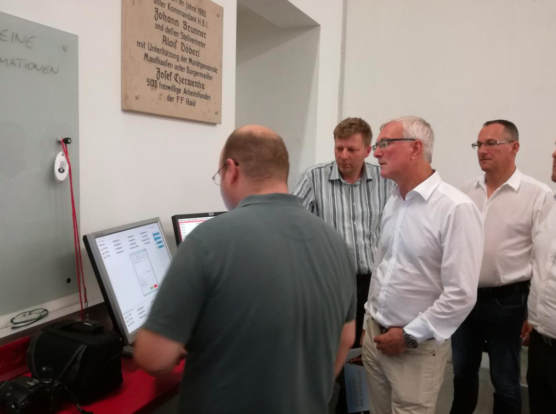 Christian Carbonari (links vorne), Kamerad der FF Haid, zeigt seine speziell entwickelte Verwaltungssoftware für Feuerwehren; v.l.n.r.: HBI Bauernfeind Franz (Kommandant FF Haid), LR Elmar Podgorschek, LAbg. Alexander Nerat.