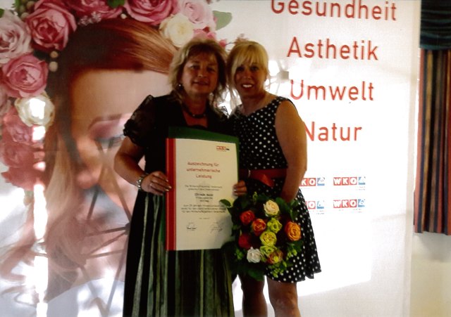 Elfriede Maier (links) zeigt stolz ihre Urkunde zum Firmenjubiläum.