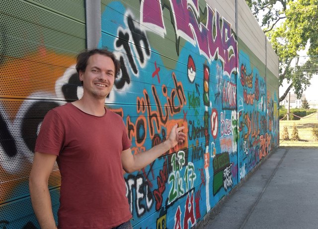 Streetworker Benedikt vor der neu gestalteten Wand.