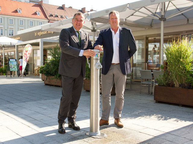 Baustadtrat DI Franz Dinhobl und Wassermeister Manfred Becker (Wasserwerke) präsentieren den neuen Trinkwasserspender vor dem Marienmarkt am Wiener Neustädter Hauptplatz