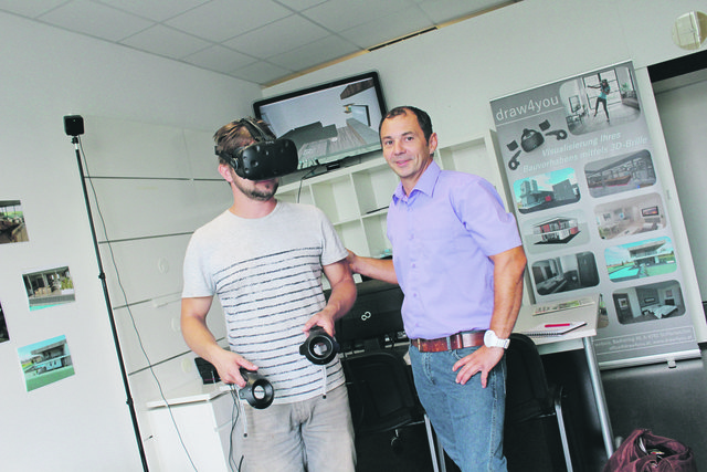 Mittels 3D-Brille wandert Gerald Lachtner (links) durchs Haus – siehe Bildschirm hinten. Joachim Till erklärt, wie's geht.