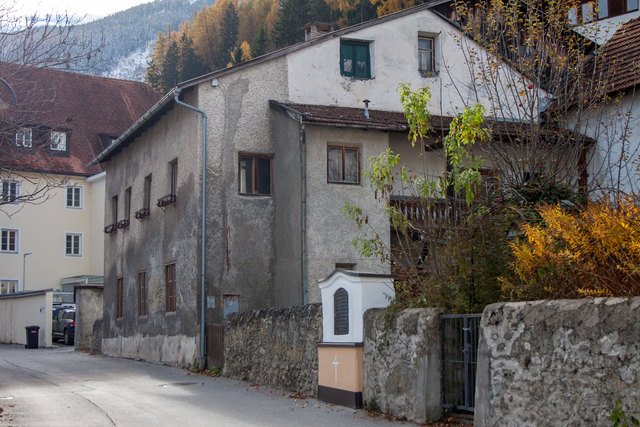 Bild 30: Das Nebenhaus der Gerburg (HNr. 23). Dieses Doppelhaus wird leider dem Verfall preisgegeben? Als eine Besonderheit hatte das Nebengebäude eine Hauskapelle aufzuweisen. Hier hing das Altarblatt (1504) des einstigen Annenaltares der Pfarrkirche, welches heute im Museum Ferdinandeum in Innsbruck zu sehen ist.

Im Hintergrund ist ein Teil der nördlichen Fassade der Gerburg (HNr. 21) zu sehen. In deren 2. Stock befindet sich in einem Büro ein Fresko, das die Gerburg als Hintergrund eines volkstümlichen Festzuges zeigt. | Foto: © Copyright Ing. Günter Kramarcsik
