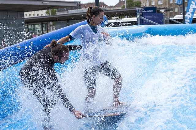 Surflehrer Dominik Müller zeigt bz-Praktikatin Giulia Mozzato, wie man länger als eine Sekunde am Brett bleibt.