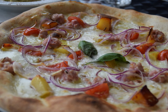 Pizza "A casa" mit sizilianischer Rohwurst, Büffelmozzarella, Kirschtomaten, Zwiebeln und Kartoffeln.