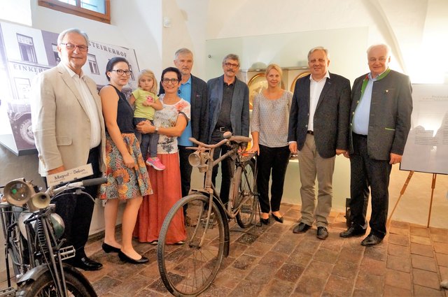 Die Familie Roch mit Museumsleitung und Ehrengästen mit dem ersten Fahrrad aus dem Geschäft am Hauptplatz.