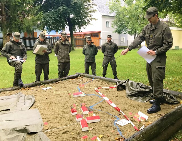 Rath weist seine Zugskommandanten anhand eines Geländesandkastens in den Ablauf der Übung ein. | Foto: Klug/Gießauf