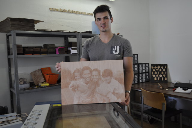 Mithilfe einer speziellen Maschine stellt Dominik Pototschnig die verschiedenen Holz-Fotogravur Produkte her