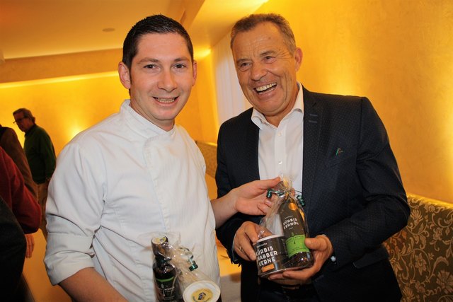 Kernöl als Gruß der Tourismusgemeinde Kalsdorf: Hotelchef Alexander Meyer und Schilegende Erik Schinegger