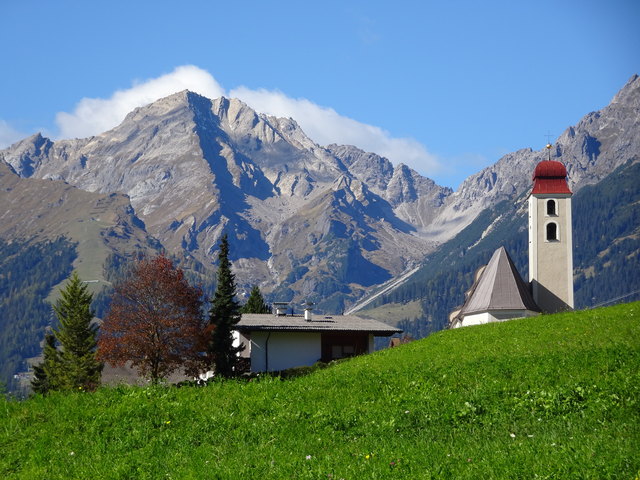 Richtung Nordwesten gesehen beeindrucken hinter der barocken Kirche von Karrösten die Lechtaler Alpen