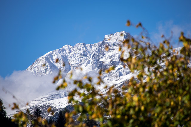 Winter auf den Bergen und Herbst im Tal
