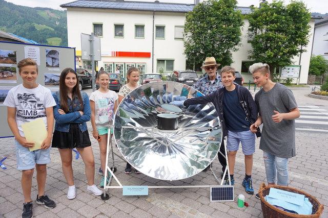 Am Tag der Sonne kochen Schüler mit dem Solarkocher Würstl für Passanten. | Foto: Gde. St. Johann