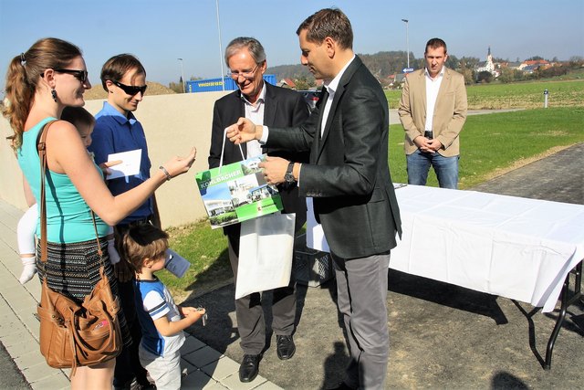 Familie Hasewend übernimmt von Bernd Kohlbacher die Schlüssel zum Eigenheim sowie von Bgm. Werner Kirchsteiger ein Willkommenssackerl der Gemeinde.