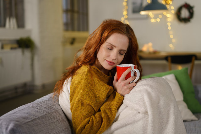 frau wärmt sich mit einer tasse tee