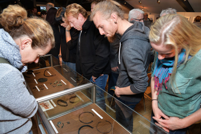 Ausstellungbesucher studieren die Fundstücke in den Vitrinen.