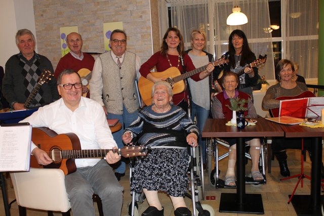 Simply Guitar Stammtischrunde beim Besuch im Caritas Seniorenwohnhaus Schloss Hall mit Sandra Fakler (hi.4.v.li.) und Andras Kaltenböck, Leiterin Aktivteam (hi.5.v.li)