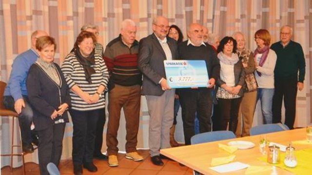 Die Mitarbeiter am Basar übergeben den Scheck an Pfarrer Thomas Bergner. | Foto: Irmgard Walcher