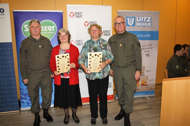 Karlheinz Buchegger (li) und Heinz Zöllner danken Ingrid Kienzl und Brigitte Winkelmayer sowie den Schülern der NMS Hitzendorf mit einer Kekserl-Urkunde.