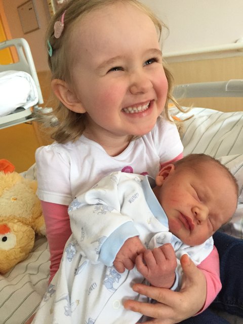 Laureen hält ganz stolz das erste mal ihren kleinen Bruder in der Hand