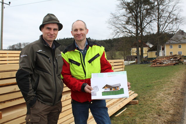 Forstberater Andreas Krempl (l.) und Bio-Bauer Josef Hehenfelder mit dem Bauplan für das Auszughaus. Das Fichtenholz aus dem eigenen Wald liegt bereits geschnitten am Bauplatz bereit.