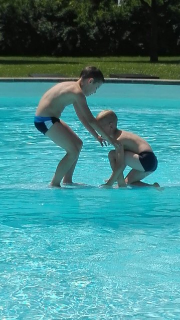 Großer Bruder lernt den Kleineren das Wasserlaufen