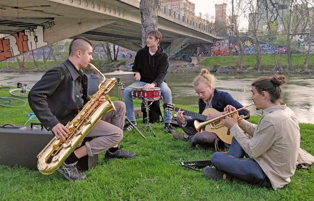 Vier der sechs Mitglieder von Buntspecht spielen am Donaukanal.