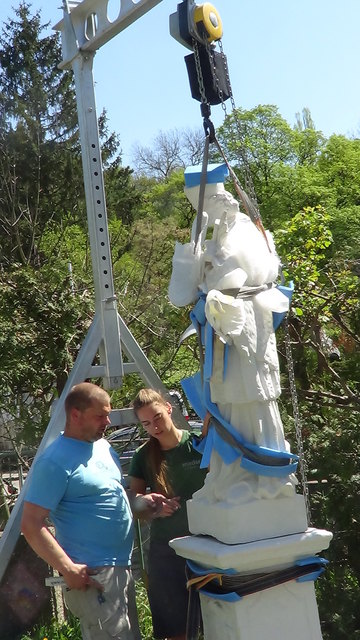 Restauratoren mit der am Kran hängenden Statue