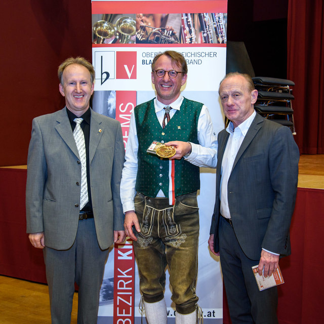 Die Wertungsjuroren gratulieren Kapellmeister Manfred Payrhuber (mitte) zur goldenen Medaille.