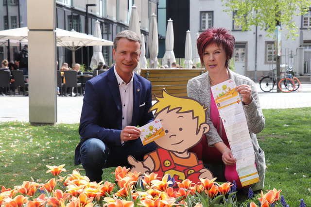 Gemeinsam mit Maskottchen „Peterle“ präsentieren Vizebürgermeister Christoph Kaufmann und Referatsleiterin Uschi Klee (Frauen und Generationen) die aktuelle Ausgabe des Familienkalenders.