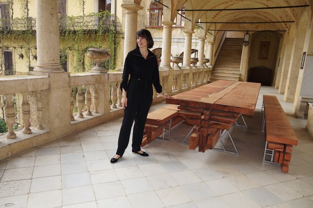 Kuratorin Alice Stori Liechtenstein und der Tisch aus dem Holz eines Mamutbaumes - praktisch, nachhaltig und an ein Holzlager erinnernd, eben Holztreff Liechtenstein.