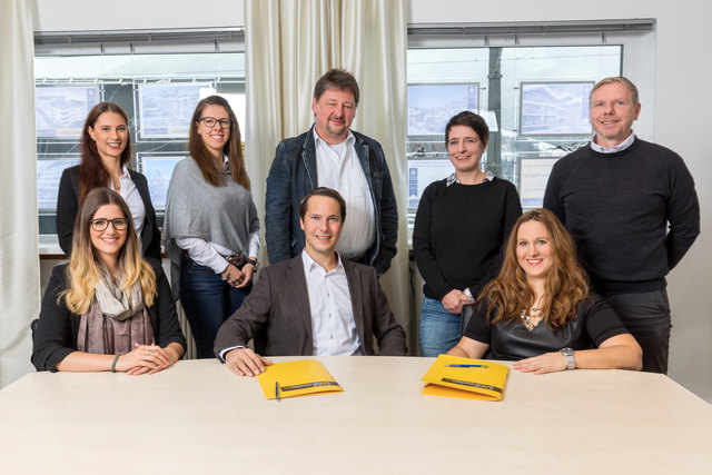 Mag. Eva Hausegger (sitzend, rechts) und Mag. (FH) Stefan Gassner (in der Mitte sitzend) von SAGE Immobilien in Zell am See mit ihrem Team.