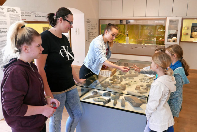 FW-Schülerinnen Jacqueline Gangl, Denise Komornik und Hannah Straka, wie sie VS-Kindern die Jungsteinzeit erklären.