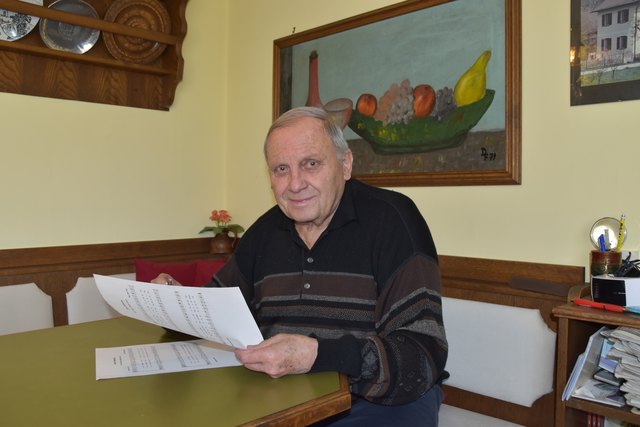 Dieter Fleiß in der Küche seines Hauses vor einem selbst gemalten Bild und natürlich mit einem Notenblatt in der Hand