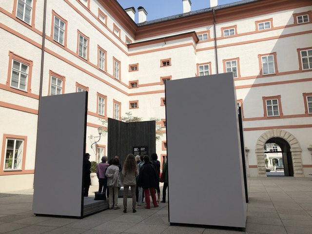 Die Installation in der Neuen Residenz erinnert an aufgeschlagene Bücher, deren inneres verkohlt ist.