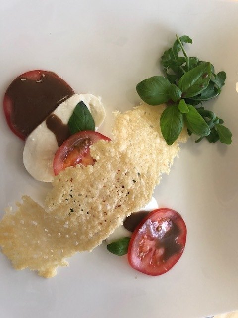 Kalte Vorspeise: Tomaten mit Mozzarella, Rucola und Parmesanhippe. | Foto: Koidl