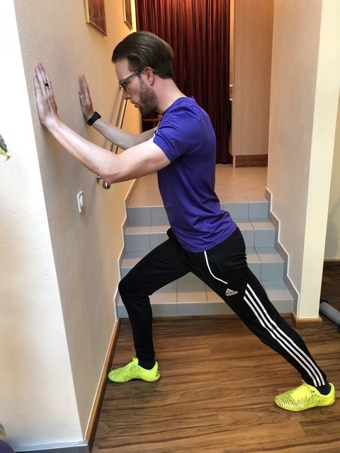 Das Knie geht langsam immer mehr Richtung Wand, während die Fersen weiterhin am Boden bleiben. Anschließend erfolgt ein Wechsel und das andere Bein ist an der Reihe.