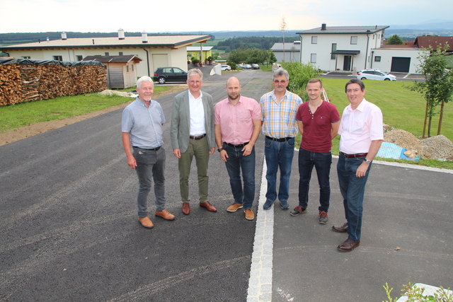 Bgm. Günter Müller und Vzbgm. Walter Berghofer mit Vertretern der am Bau beteiligten Firmen am neu asphaltierten „Sonnenhang“.