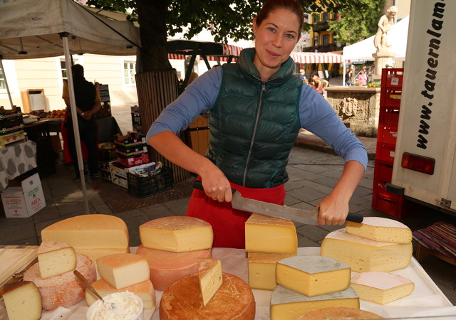 Elisa Zehentner mit Käseprodukten und frischen Krapfen und Backwaren.