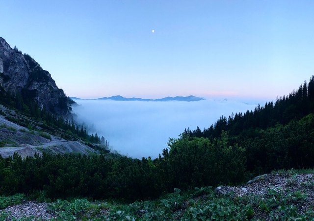 Blauer Himmel und der Mond über dem Nebelmeer.