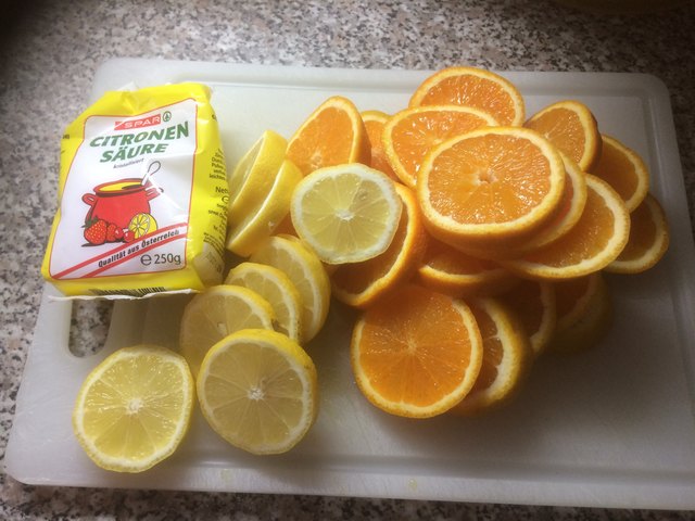 3 Zitronen und 4 Orangen in Scheiben schneiden und 5 dag Zitronensäure