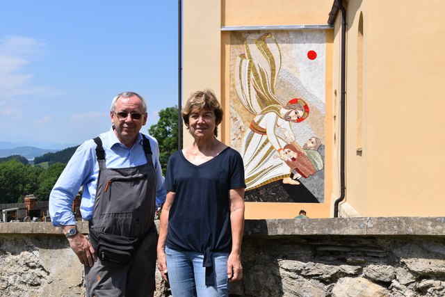 Künstler Marko Rupnik mit Pfarrgemeinderatsobfrau Maria Ackermann vor dem fertigen Mosaik an der Kirchenwand