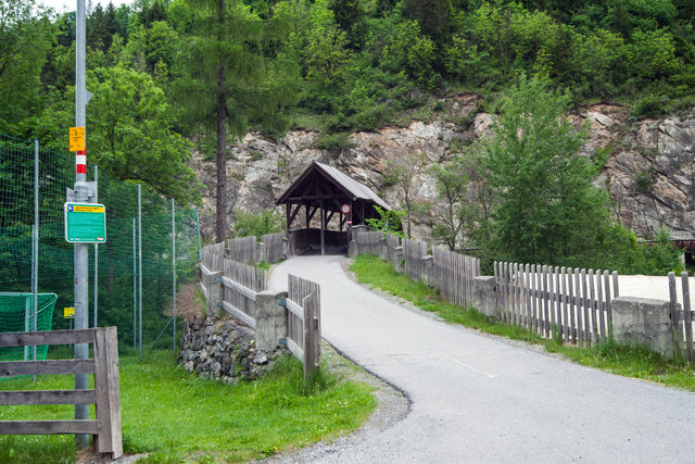 Der Innradweg und der Radweg Via Claudia Augusta zwischen Landeck und Nesselgarten (Fließ) wechselt nun über eine alte Holzbrücke auf die andere Innseite. Am anderen Ende der überdachten Holzbrücke setzt sich eine schmale "Trogbrücke" als Hangbrücke und parallel zur L76 bis kurz vor Nesselgarten fort. Hier wäre der Zeit entsprechend eine Verbesserung notwendig, weil der Querschnitt der Hangbrücke zwischenzeitlich zu schmal ist.  | Foto: © by Ing. Günter Kramarcsik