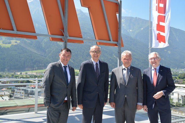 Pfaffenhofer Bgm. Andreas Schmid, Anton Mederle, Helmut Thöni und Thomas Bock. Im Hintergrund links die Gemeinde Pfaffenhofen, die Kräne zeigen den neuen Thöni-Standort an.